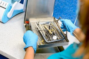 Sterile Processing technician holding tray full of instruments. Instruments prepared to be sterilized. Technician training for crcst certification. Sterile Processing technician certification 